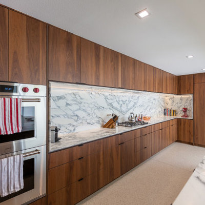Example of a large 1950s single-wall terrazzo floor, white floor and exposed beam eat-in kitchen design in Other with an undermount sink, flat-panel cabinets, dark wood cabinets, quartz countertops, white backsplash, quartz backsplash, paneled appliances, a peninsula and white countertops