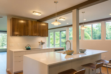 Small retro single-wall kitchen/diner in Boston with a submerged sink, flat-panel cabinets, white cabinets, composite countertops, dark hardwood flooring and an island.