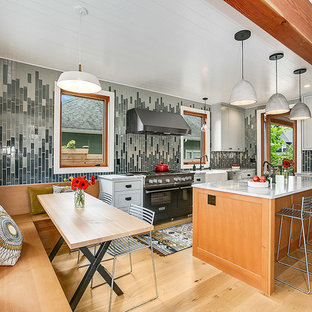 Diseño de cocina comedor retro con fregadero sobremueble, armarios estilo shaker, puertas de armario grises, encimera de mármol, salpicadero multicolor, electrodomésticos de acero inoxidable, suelo de madera clara, una isla y encimeras grises