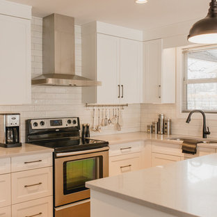 This is an example of a small midcentury u-shaped open plan kitchen in Other with an undermount sink, shaker cabinets, white cabinets, quartz benchtops, white splashback, subway tile splashback, stainless steel appliances, vinyl floors, a peninsula, brown floor and white benchtop.