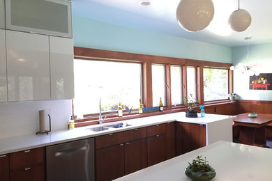 Small 1950s l-shaped ceramic tile eat-in kitchen photo in Other with a double-bowl sink, recessed-panel cabinets, quartz countertops, white backsplash, ceramic backsplash, stainless steel appliances and a peninsula