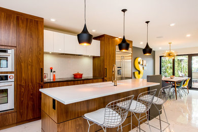 Eat-in kitchen - large mid-century modern l-shaped porcelain tile eat-in kitchen idea in Other with an undermount sink, flat-panel cabinets, medium tone wood cabinets, quartzite countertops, white backsplash, ceramic backsplash, stainless steel appliances and an island