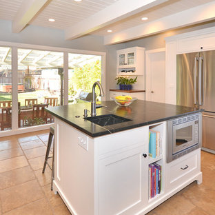 Foto di una cucina ad U minimalista chiusa e di medie dimensioni con lavello a vasca singola, ante in stile shaker, ante bianche, top in marmo, paraspruzzi bianco, paraspruzzi con piastrelle in ceramica, elettrodomestici in acciaio inossidabile, pavimento in terracotta e isola