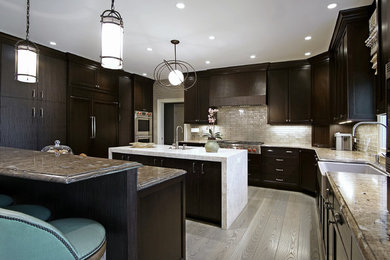 Eat-in kitchen - large contemporary l-shaped light wood floor eat-in kitchen idea in Chicago with a farmhouse sink, dark wood cabinets, stainless steel appliances, two islands, flat-panel cabinets, granite countertops, metallic backsplash and glass tile backsplash