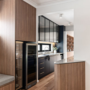 Design ideas for a mid-sized contemporary galley separate kitchen in Sydney with a double-bowl sink, blue cabinets, quartz benchtops, grey splashback, engineered quartz splashback, stainless steel appliances, medium hardwood floors, no island, brown floor and grey benchtop.