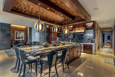 Example of a large trendy l-shaped porcelain tile kitchen design in Omaha with an undermount sink, recessed-panel cabinets, dark wood cabinets, granite countertops, black backsplash, glass tile backsplash, paneled appliances, an island and multicolored countertops