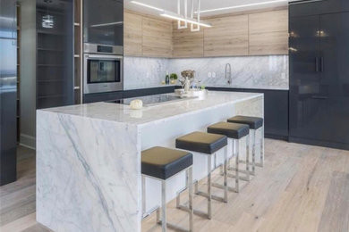 Mid-sized minimalist l-shaped light wood floor eat-in kitchen photo in Atlanta with an undermount sink, flat-panel cabinets, gray cabinets, marble countertops, white backsplash, marble backsplash, stainless steel appliances, an island and white countertops