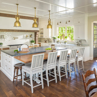 Farmhouse eat-in kitchen ideas - Example of a country l-shaped dark wood floor eat-in kitchen design in Salt Lake City with a farmhouse sink, shaker cabinets, white cabinets, stainless steel appliances and an island