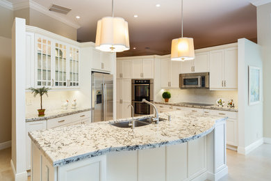 Mid-sized elegant l-shaped porcelain tile and beige floor open concept kitchen photo in Miami with an undermount sink, recessed-panel cabinets, white cabinets, granite countertops, white backsplash, porcelain backsplash, stainless steel appliances, an island and white countertops