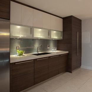 Ispirazione per una cucina moderna di medie dimensioni con lavello da incasso, ante lisce, ante in legno scuro, top in superficie solida, paraspruzzi verde, paraspruzzi con piastrelle a mosaico, elettrodomestici in acciaio inossidabile, pavimento con piastrelle in ceramica e nessuna isola