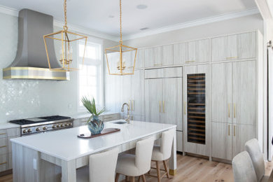 Inspiration for a large coastal u-shaped light wood floor, beige floor and tray ceiling eat-in kitchen remodel in Miami with a drop-in sink, flat-panel cabinets, light wood cabinets, quartzite countertops, white backsplash, ceramic backsplash, paneled appliances, an island and white countertops