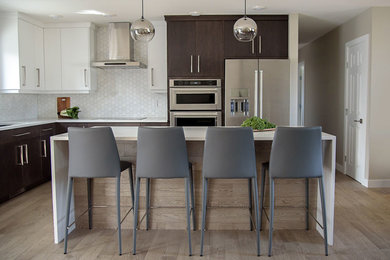 Example of a trendy l-shaped medium tone wood floor kitchen design in Other with an undermount sink, flat-panel cabinets, white cabinets, quartz countertops, white backsplash, stone tile backsplash, stainless steel appliances and an island
