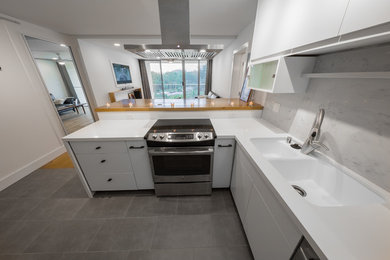 Inspiration for a small contemporary l-shaped kitchen/diner in Hawaii with a double-bowl sink, flat-panel cabinets, white cabinets, composite countertops, blue splashback, marble splashback, stainless steel appliances, porcelain flooring, grey floors and white worktops.