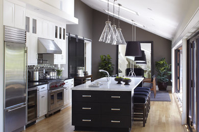 Inspiration for a huge transitional single-wall light wood floor, beige floor and vaulted ceiling eat-in kitchen remodel in San Francisco with stainless steel appliances, subway tile backsplash, brown backsplash, shaker cabinets, marble countertops, an undermount sink, white countertops and an island