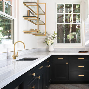 Design ideas for a mid-sized transitional u-shaped eat-in kitchen in San Francisco with panelled appliances, black cabinets, marble benchtops, grey splashback, with island, an undermount sink, open cabinets, stone slab splashback, medium hardwood floors and beige floor.