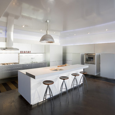Example of a trendy kitchen design in Seattle with flat-panel cabinets, white cabinets, laminate countertops and paneled appliances