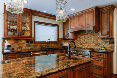 Large rustic kitchen in Chicago with a submerged sink, raised-panel cabinets, granite worktops, stone tiled splashback, stainless steel appliances and an island.