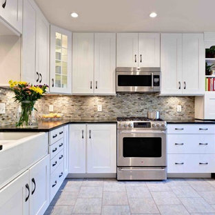 This is an example of a small transitional u-shaped eat-in kitchen in Atlanta with a farmhouse sink, recessed-panel cabinets, white cabinets, soapstone benchtops, multi-coloured splashback, glass tile splashback, stainless steel appliances, porcelain floors, with island, beige floor and green benchtop.