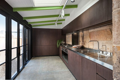 Exempel på ett mellanstort modernt linjärt kök, med en dubbel diskho, bänkskiva i rostfritt stål, stänkskydd i sten, betonggolv, grått golv och rostfria vitvaror