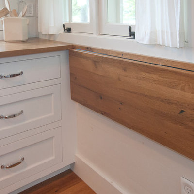 Inspiration for a coastal galley kitchen remodel in Other with shaker cabinets, white cabinets and wood countertops