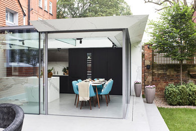 Imagen de cocina comedor contemporánea grande con fregadero bajoencimera, armarios con paneles lisos, puertas de armario de madera en tonos medios, encimera de mármol, salpicadero blanco, salpicadero de mármol, electrodomésticos con paneles, suelo de cemento, una isla, suelo gris y encimeras blancas