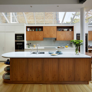 Foto de cocina actual, extra grande, abierta, con salpicadero verde, una isla, armarios con paneles lisos y encimera de cuarcita