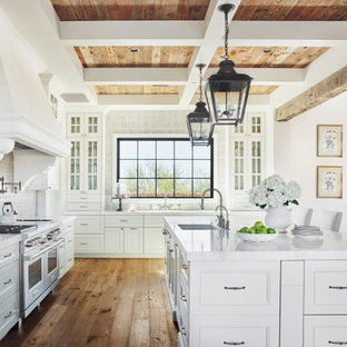 Traditional u-shaped eat-in kitchen in Phoenix with an undermount sink, recessed-panel cabinets, white cabinets, grey splashback, stainless steel appliances, medium hardwood floors, with island, brown floor, white benchtop, coffered, exposed beam and wood.