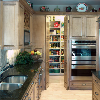 Example of a classic light wood floor kitchen design in Omaha with an undermount sink, recessed-panel cabinets, medium tone wood cabinets, gray backsplash and stainless steel appliances