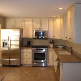 Small traditional l-shaped eat-in kitchen in Chicago with an undermount sink, recessed-panel cabinets, white cabinets, granite benchtops, stainless steel appliances, ceramic floors and no island.