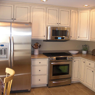 This is an example of a small traditional l-shaped eat-in kitchen in Chicago with an undermount sink, recessed-panel cabinets, white cabinets, granite benchtops, stainless steel appliances, ceramic floors and no island.