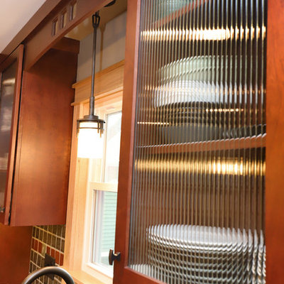 Inspiration for a mid-sized craftsman l-shaped eat-in kitchen remodel in Grand Rapids with shaker cabinets, medium tone wood cabinets, granite countertops, multicolored backsplash, ceramic backsplash, stainless steel appliances and an island