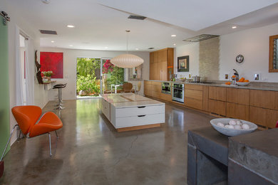 Photo of a large modern single-wall kitchen/diner in Santa Barbara with an integrated sink, shaker cabinets, medium wood cabinets, limestone worktops, beige splashback, ceramic splashback, stainless steel appliances, concrete flooring and no island.