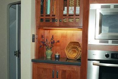 Example of a small cottage galley cork floor enclosed kitchen design in Other with an undermount sink, shaker cabinets, medium tone wood cabinets, solid surface countertops, blue backsplash and stainless steel appliances
