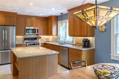 Example of a large arts and crafts l-shaped marble floor and white floor eat-in kitchen design in Boston with shaker cabinets, beige backsplash, subway tile backsplash, stainless steel appliances, an island, an undermount sink, medium tone wood cabinets and granite countertops