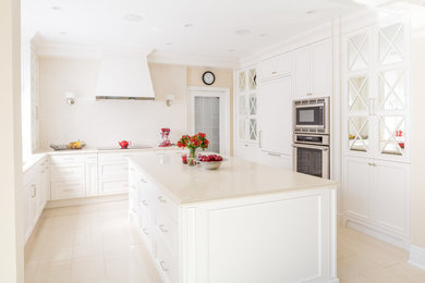 Example of a classic kitchen design in Toronto with shaker cabinets, white cabinets, stainless steel appliances and an island