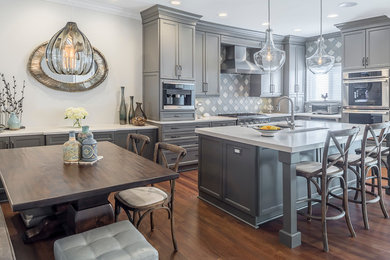 Mid-sized transitional l-shaped medium tone wood floor enclosed kitchen photo in Other with an undermount sink, recessed-panel cabinets, gray cabinets, quartz countertops, gray backsplash, porcelain backsplash, stainless steel appliances and an island