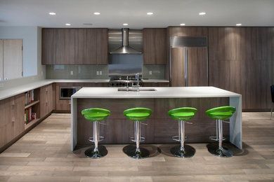 Open concept kitchen - mid-sized contemporary l-shaped light wood floor and brown floor open concept kitchen idea in Edmonton with an undermount sink, flat-panel cabinets, light wood cabinets, quartz countertops, glass tile backsplash, paneled appliances, an island and gray backsplash