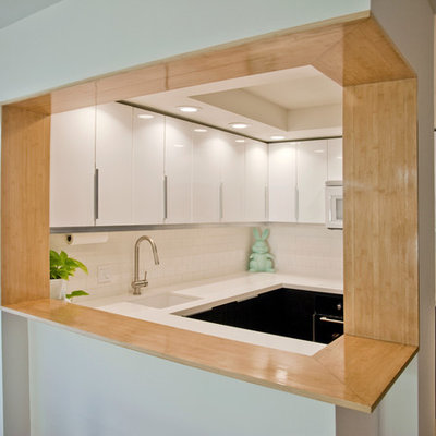 Kitchen - modern u-shaped kitchen idea in San Diego with flat-panel cabinets, white cabinets, white backsplash, subway tile backsplash and black appliances