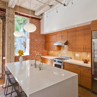 Idee per una cucina parallela minimal con elettrodomestici in acciaio inossidabile, lavello integrato, ante lisce, ante in legno scuro e top in quarzo composito