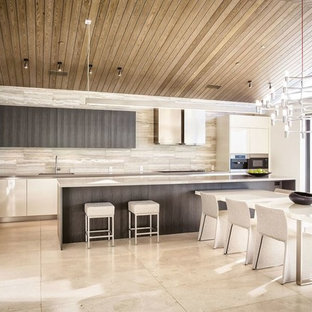 This is an example of a mid-sized modern galley open plan kitchen in San Francisco with an undermount sink, flat-panel cabinets, dark wood cabinets, zinc benchtops, brown splashback, stone tile splashback, stainless steel appliances, travertine floors and with island.