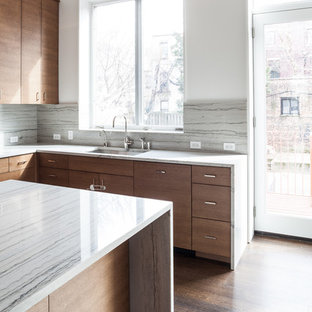 Diseño de cocina comedor en U, minimalista, de tamaño medio, con fregadero bajoencimera, armarios con paneles lisos, puertas de armario de madera en tonos medios, encimera de mármol, salpicadero verde, salpicadero de losas de piedra, electrodomésticos de acero inoxidable, suelo de madera oscura, una isla y suelo marrón