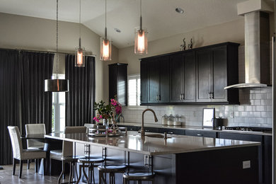 Eat-in kitchen - mid-sized modern single-wall porcelain tile eat-in kitchen idea in Tampa with an undermount sink, shaker cabinets, black cabinets, quartz countertops, ceramic backsplash, stainless steel appliances, an island, gray countertops and white backsplash
