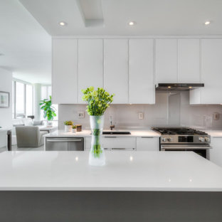 Inspiration pour une petit cuisine américaine parallèle minimaliste avec un évier encastré, un placard à porte plane, des portes de placard blanches, un plan de travail en quartz modifié, une crédence grise, une crédence en feuille de verre, un électroménager en acier inoxydable, un sol en bois brun, un îlot central, un sol gris, un plan de travail blanc et un plafond à caissons.