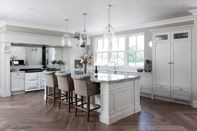 Photo of a medium sized traditional l-shaped kitchen in Other with an island, a double-bowl sink, grey cabinets, mirror splashback, white appliances, dark hardwood flooring, brown floors, grey worktops and shaker cabinets.