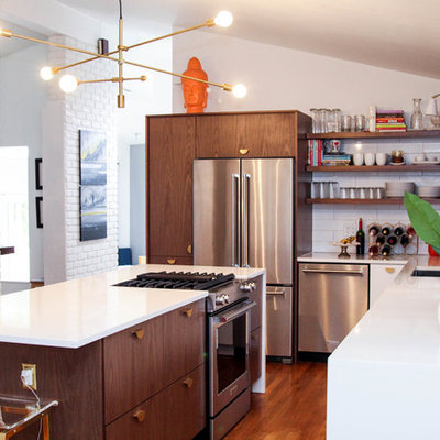Inspiration for a mid-sized mid-century modern l-shaped medium tone wood floor and brown floor enclosed kitchen remodel in Cincinnati with an undermount sink, flat-panel cabinets, dark wood cabinets, white backsplash, ceramic backsplash, stainless steel appliances, an island and white countertops