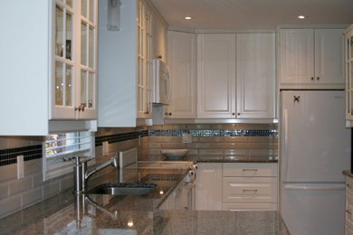 Example of a small minimalist u-shaped eat-in kitchen design in Ottawa with a single-bowl sink, raised-panel cabinets, white cabinets, granite countertops, beige backsplash, subway tile backsplash, white appliances and no island