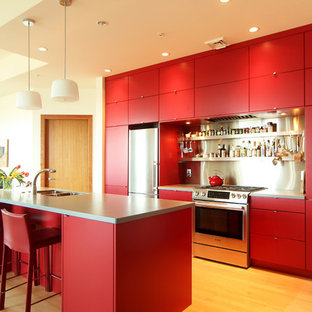 Small modern open concept kitchen appliance - Example of a small minimalist medium tone wood floor open concept kitchen design in Other with an undermount sink, flat-panel cabinets, red cabinets, solid surface countertops, metal backsplash, stainless steel appliances and an island
