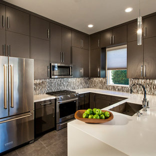 Foto de cocina en U, moderna, de tamaño medio, cerrada, con fregadero bajoencimera, puertas de armario de madera en tonos medios, encimera de acrílico, salpicadero verde, salpicadero de metal, electrodomésticos de acero inoxidable, suelo de baldosas de porcelana, una isla, armarios con paneles lisos y suelo marrón