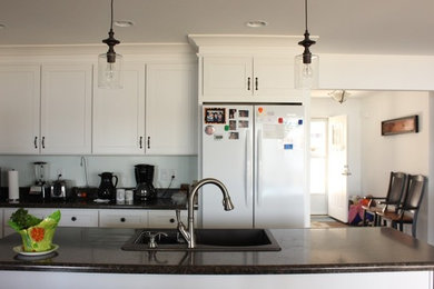 Exempel på ett mellanstort modernt kök, med en dubbel diskho, luckor med infälld panel, vita skåp, laminatbänkskiva och en köksö