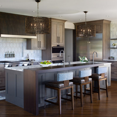 Large island style l-shaped medium tone wood floor and brown floor open concept kitchen photo in Denver with an undermount sink, recessed-panel cabinets, gray cabinets, white backsplash, marble backsplash, stainless steel appliances, an island, white countertops and marble countertops